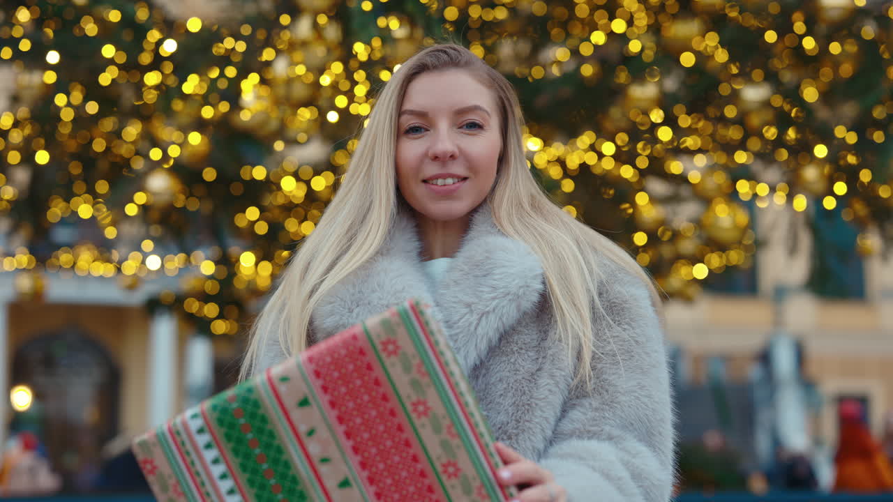Woman with Gift in Front of Christmas Tree