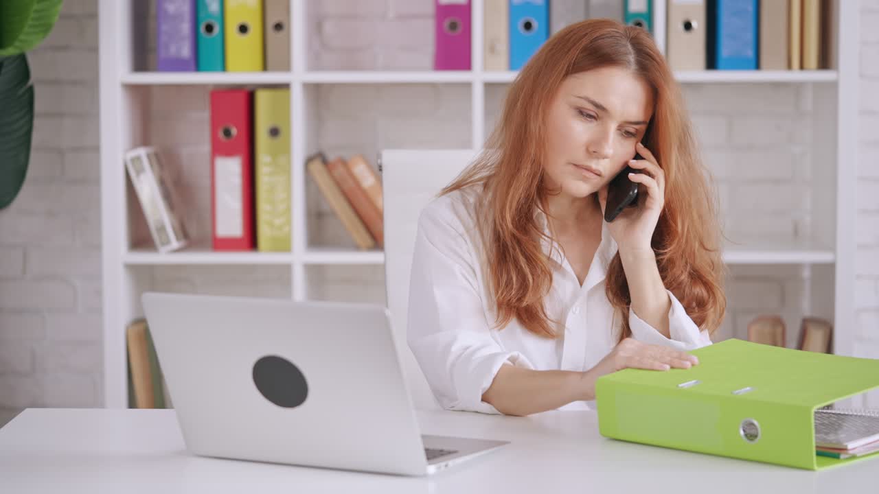 Forretningskvinde arbejder siddende ved skrivebordet.