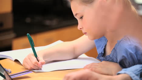 little girl writing on a notebook