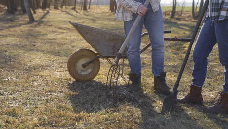 caucasian couple removing weeds with a rake in the countryside