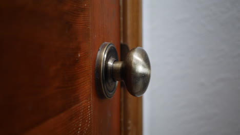 Cleaning-and-sanitizing-a-door-knob-covered-in-germs-and-corona-virus-with-a-disinfecting-antibacterial-wipe-in-a-home-to-stay-healthy-and-safe-during-pandemic