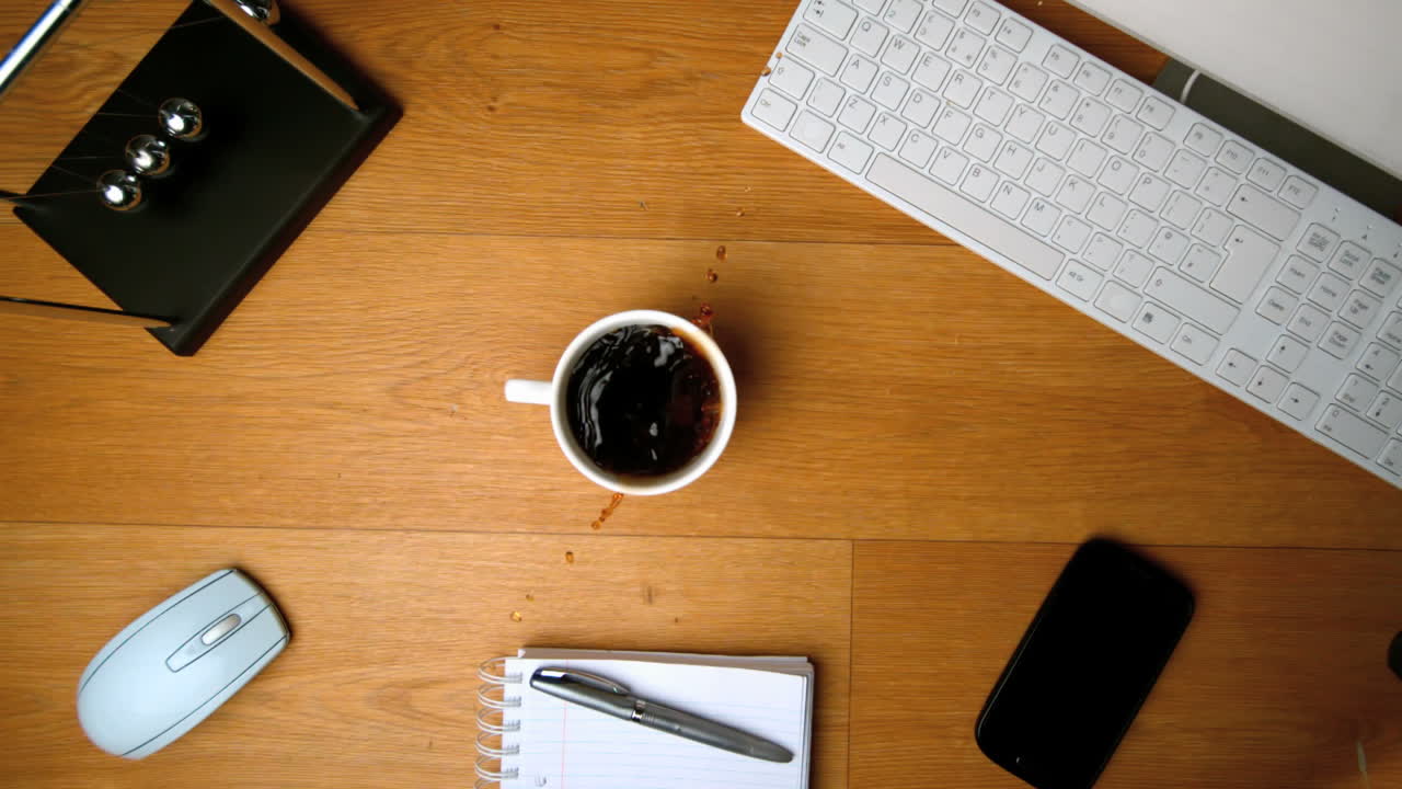 Sugar cubes falling in a coffee cup on a desk