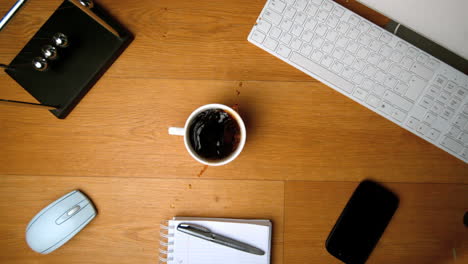 cubos de azúcar cayendo en una taza de café en un escritorio