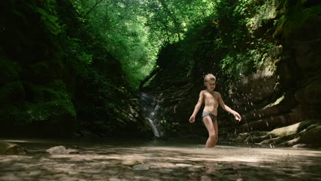 boy playing in a mountain stream