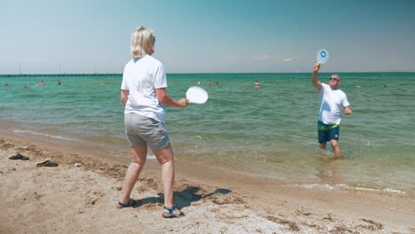 Pareja-Madura,-Juego,-Raqueta,-Pelota,-En-La-Playa