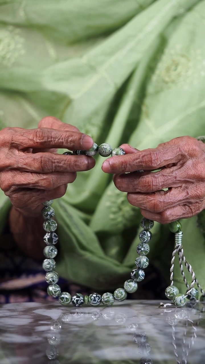Orang Lanjut Usia Berdoa dengan Tasbih Hijau