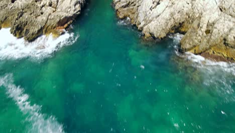 fast moving drone video of the blue and green sea following a rocky coastline during a hot and sunny summers day in montenegro