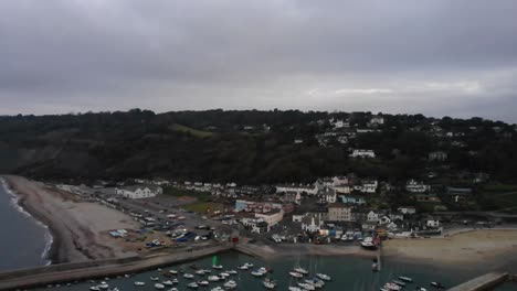 Aerial-rising-shot-of-Lyme-Regis-and-the-Cobb-Dorset-in-England-at-sunrise-on-a-cloudy-day