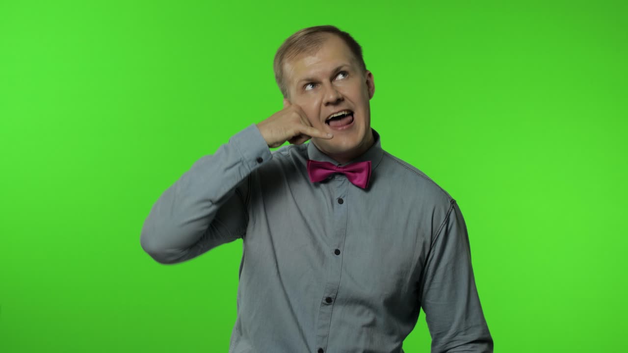 안하세요, 전화해 주세요. 전화기를 가진 남자가 머리 근처에 손짓을 하고 통신하고, 전화로 이야기합니다. 크로마 키