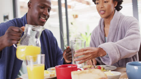 Video-of-happy-african-american-couple-drinking-juice-together