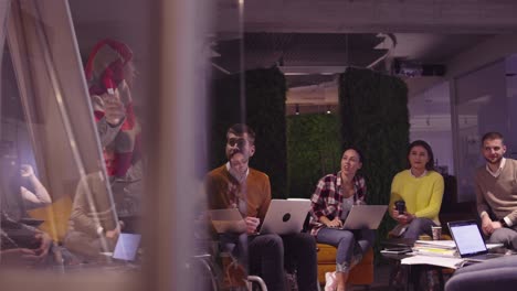 muslim woman in a modern open space coworking office giving a presentation to team. middle eastern arab businesswoman in creative startup office. disabled businessman in a wheelchair on team meeting