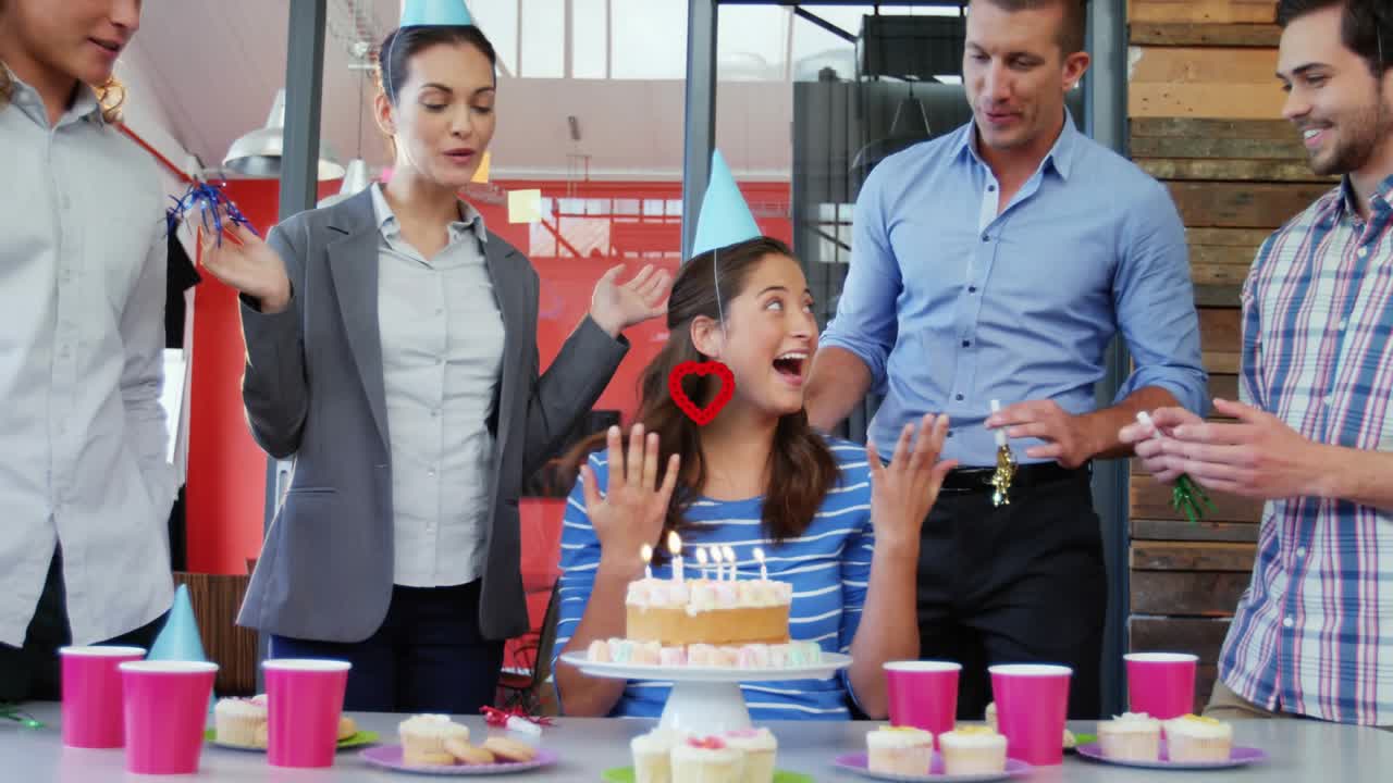 Office singing clapping and urging seated woman blowing birthday cake candles heart overlay staying