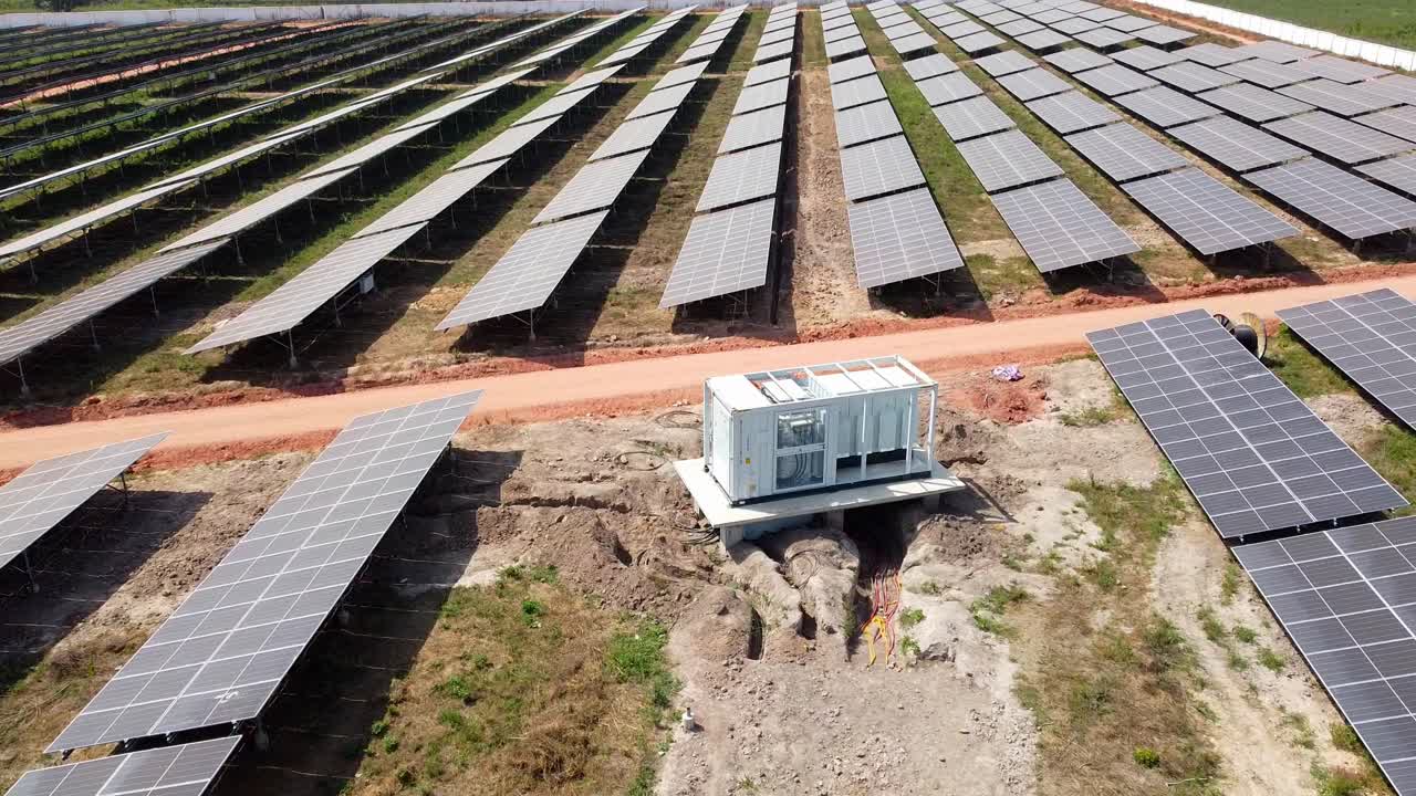 Solar PV farm industrial inverter module with visible DC combiner box cables during installation -aerial low close up view