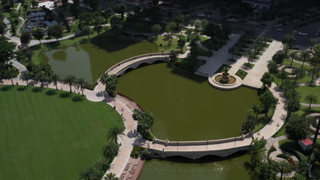 aerial-view-of-a-beautifully-landscaped-park-on-a-clear-sunny-day-with-colorful-children's-playground-tennis-courts-and-putting-green