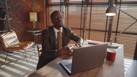 Black-Businessman-Talking-on-Web-Call-on-Laptop-at-Office-Workplace