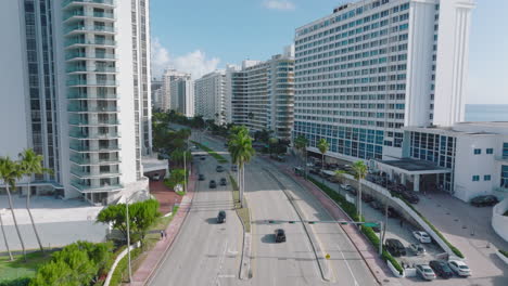 Traffic-on-trunk-road-leading-through-modern-urban-borough.-Forwards-tracking-cars-driving-on-multilane-road.-Miami,-USA