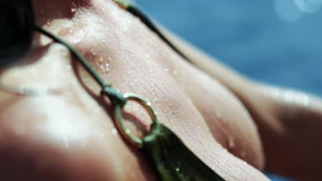 drops of water flow from the bikini woman's breasts