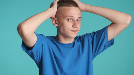 doubtful boy in blue clothing posing