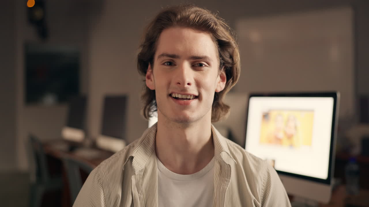 친절한 젊은이가 사무실에서 비디오 통화를 통해 인사를합니다.