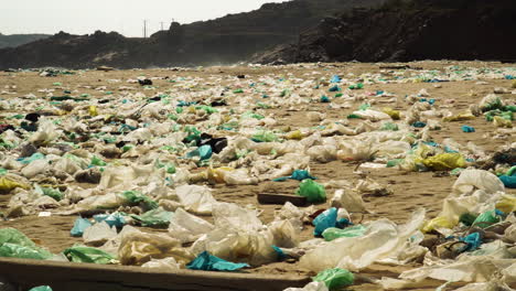 Waste-covered-sandy-beach-coastline-of-Vietnam,-pan-left-view