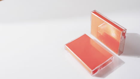 video of two retro orange cassette tape boxes with copy space on grey background