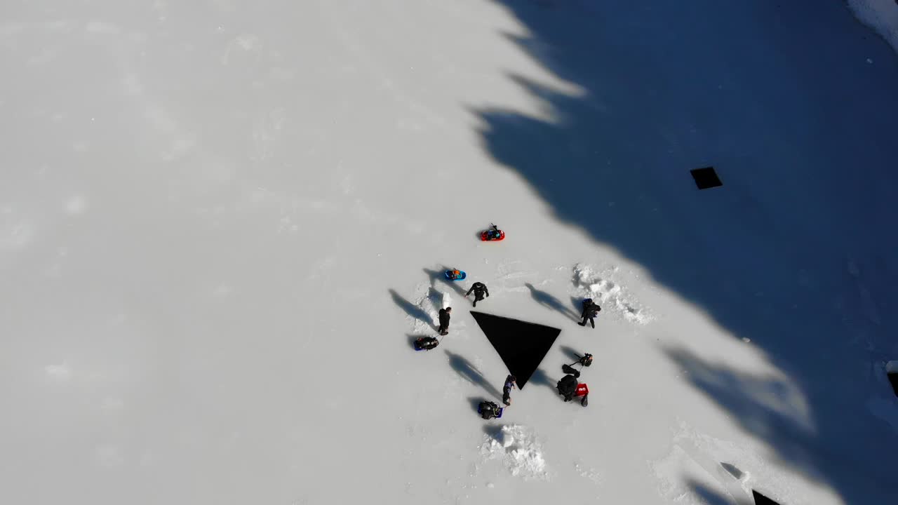 antena: buzos entrando por un agujero de hielo en un lago congelado