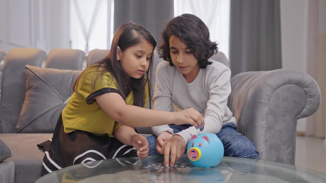 hermanos indios ahorrando dinero y poniendo monedas en la alcancía