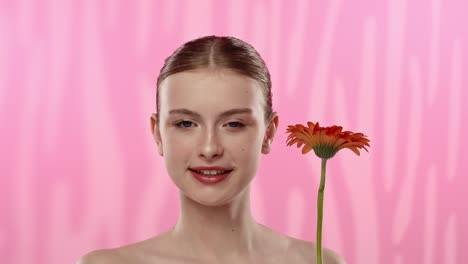 young woman with bright orange flower on vibrant background a serene moment of a woman enjoying the scent of a vibrant orange flower eyes closed in relaxation
