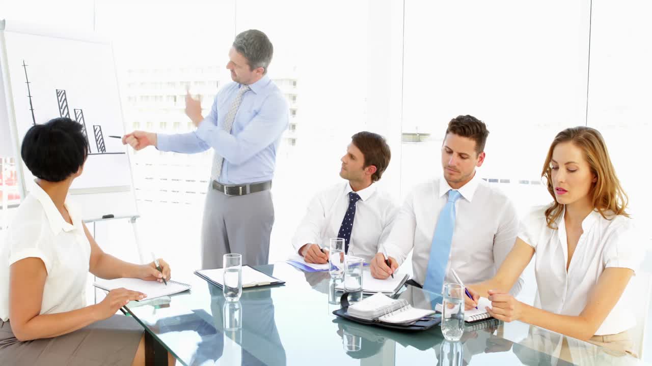 회의 도중 직원 들 에게 말 하는 사업가