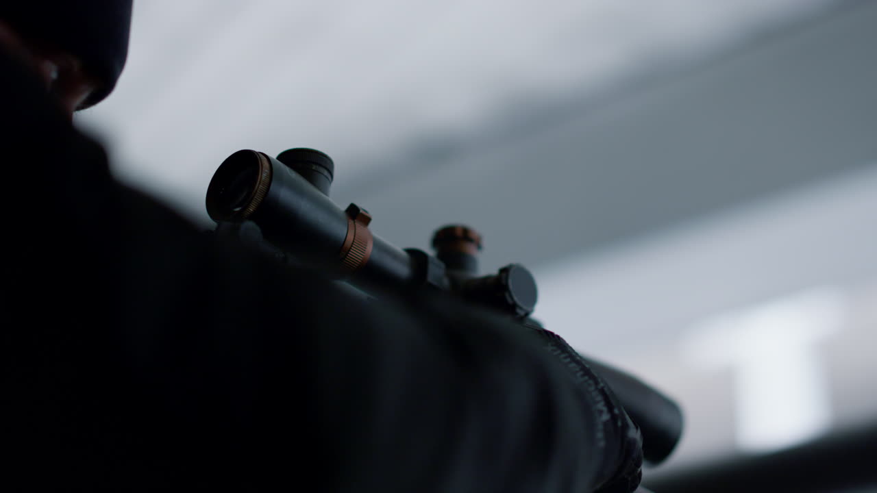 살인자는 소총의 망원경 시야를 찾고 있습니다. 저격수는 총기에 표적을 겨냥하고 있습니다.