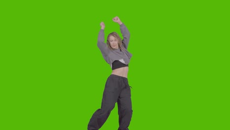 studio shot of young woman having fun dancing against green screen 36