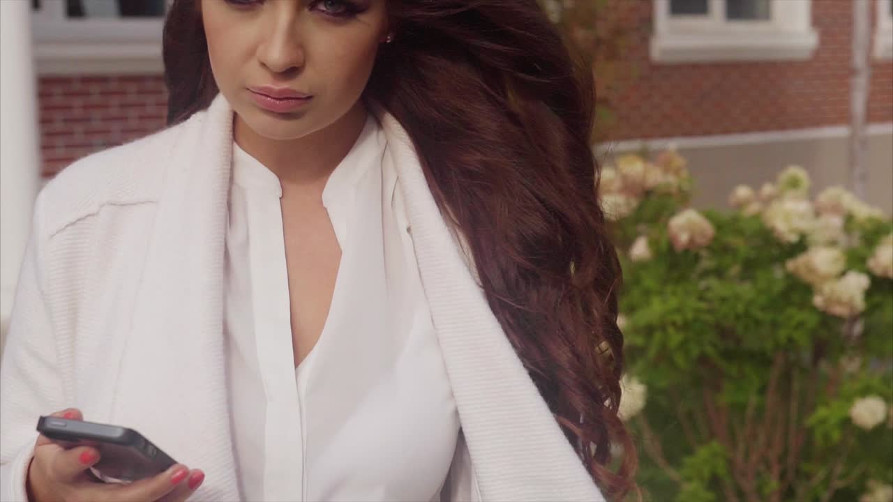 밖에서 스마트폰을 사용하는 여성