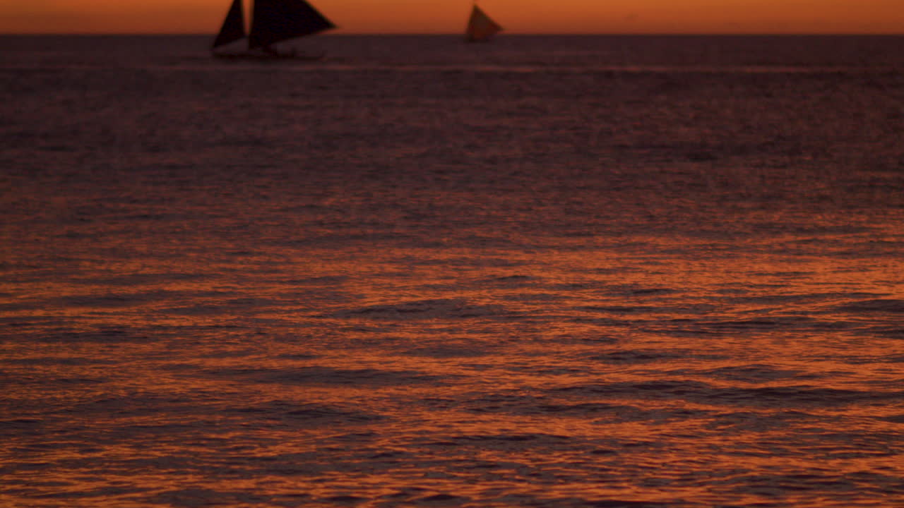 Dramatic Slow Motion Tilt Up Shot Of Sea Water And Sail Boats While Sunset