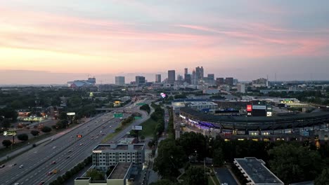 Atlanta,-Georgia-skyline-at-dusk-with-freeway-traffic-and-drone-video-moving-down