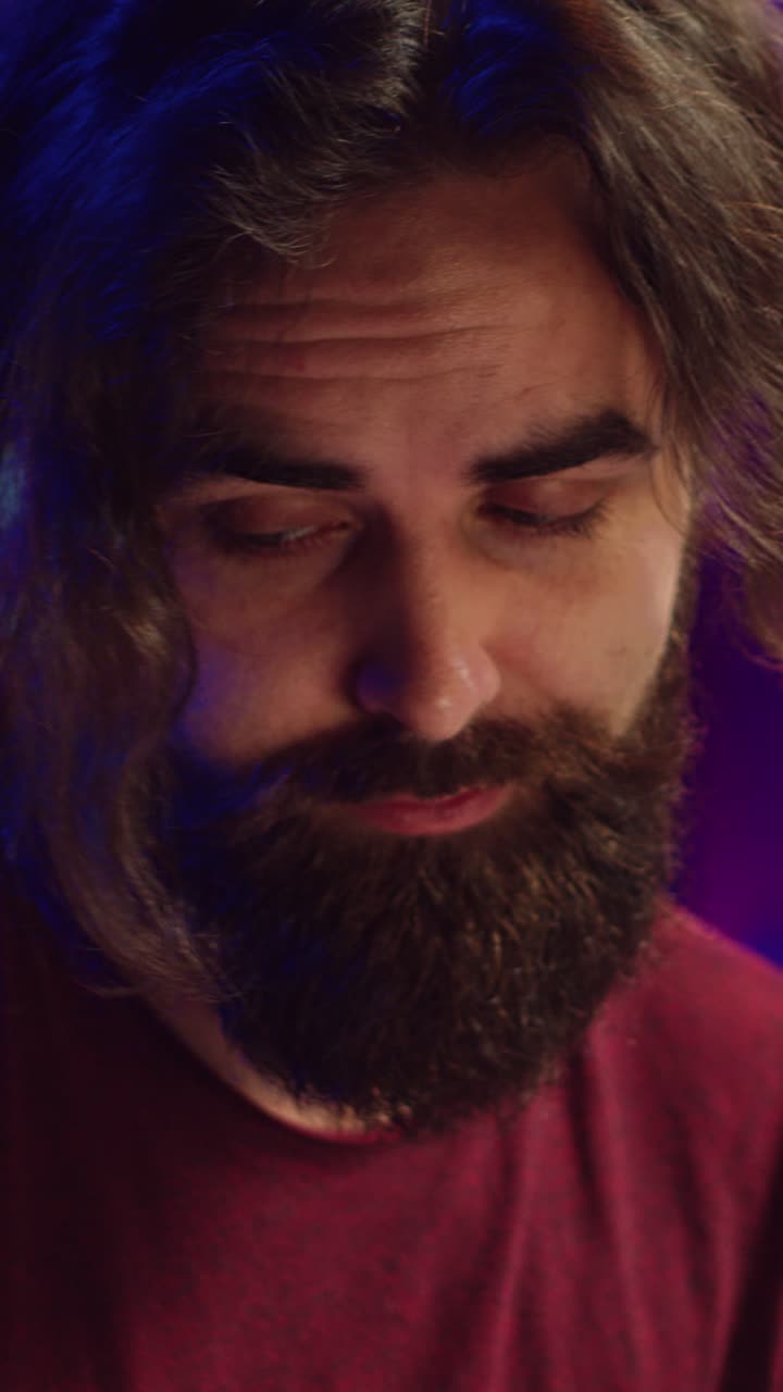 Nærbillede af musiker, der spiller på MIDI-keyboard med et fokuseret udtryk