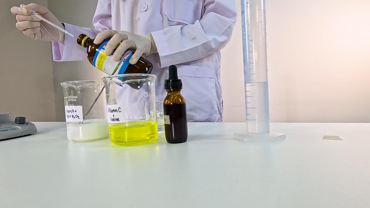 A scientist performs the iodine clock reaction, mixing solutions in a lab setting with controlled lighting