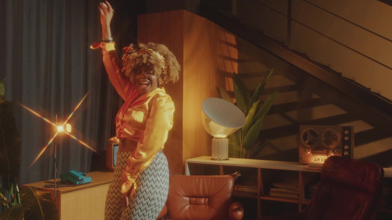 Hermosa mujer afroamericana bailando disco en un estudio de estilo retro