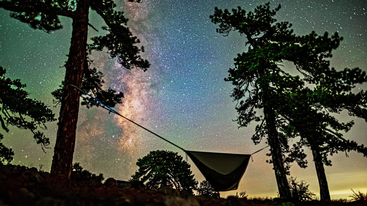 Hammock camping underneath the Milkyway stars passing overhead in a long exposure timelapse