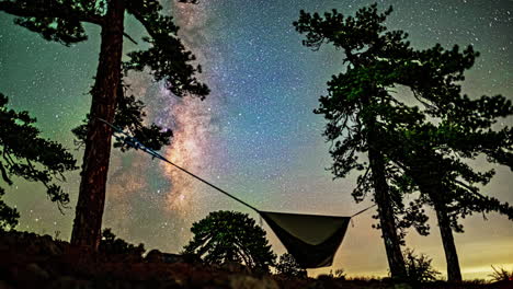 hammock camping underneath the milkyway stars passing overhead in a long exposure timelapse