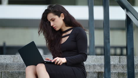 Vista-De-Cerca-De-Una-Mujer-Sentada-En-Las-Escaleras-Con-Una-Computadora-Portátil-Afuera