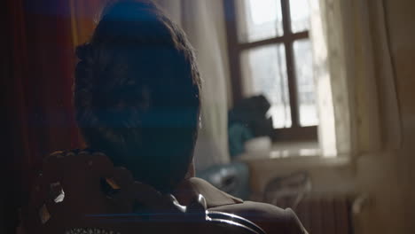 man sitting in an old room by the window