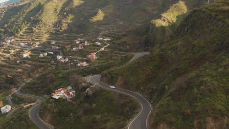 Un-Automóvil-Que-Conduce-Curvas-En-La-Calle-En-Las-Montañas