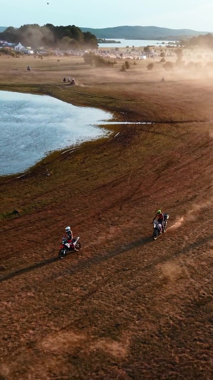 Vista aerea di piloti di motocross che gareggiano su un campo aperto al tramonto