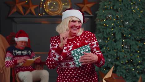 abuela mayor en suéter de navidad celebrar el éxito ganar gritar haciendo ganador manos gesto