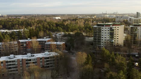 aerial, drone shot flying over apartment buildings in pitajanmaki, on a sunny, fall day, in helsinki, uusimaa, finland