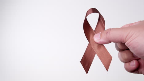 detalle de la mano masculina que sujeta la cinta en color marrón sobre fondo blanco