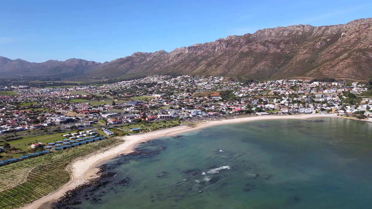 Spiaggia principale di Gordon's Bay con progetto di ripristino delle dune sulla costa di False Bay. Panoramica aerea che rivela le montagne Hottentots Holland in Sudafrica.