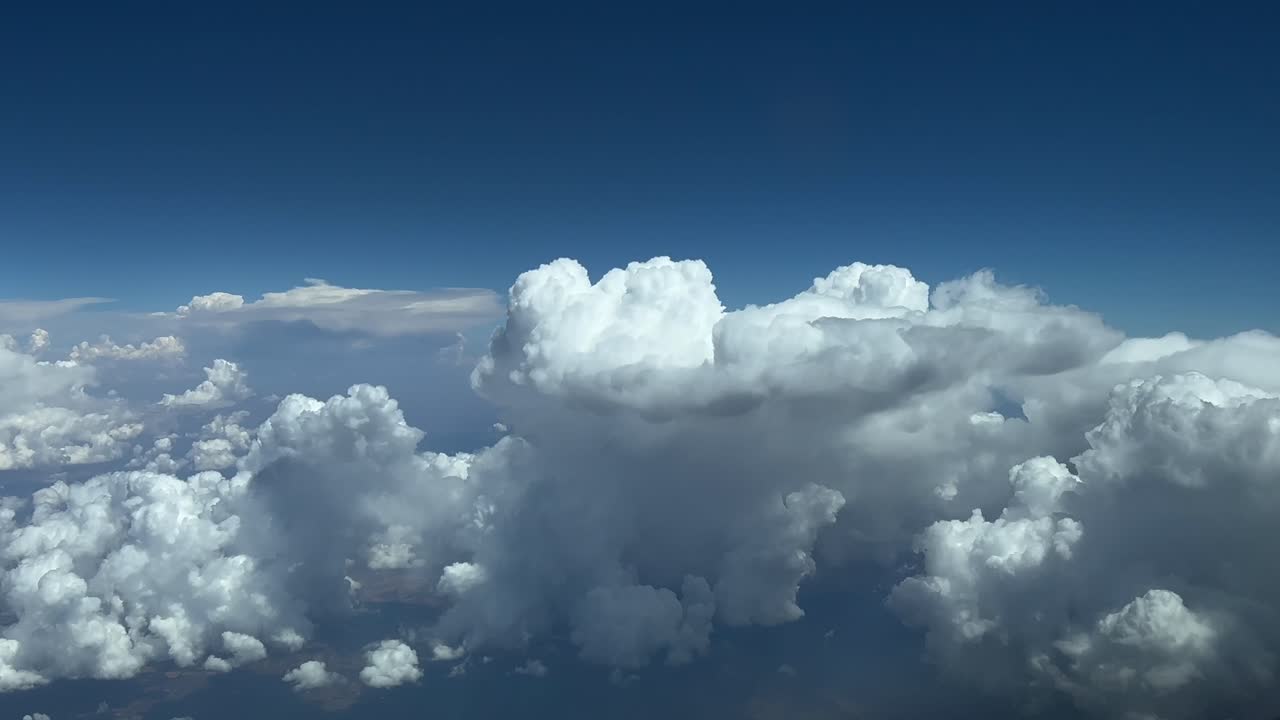 pov volando en un cielo azul tormentoso con una enorme nube de tormenta por delante