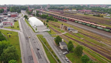 Railway-with-Cargo-Wagons-and-Roads-Intersection-in-Klaipeda,-Lithuania-from-Above