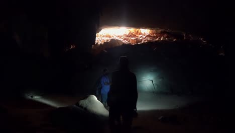 hermosa foto de mano de caminar a través de la famosa cueva lapa doce en el parque nacional chapada diamantina en bahia, noreste de brasil con la salida de la cueva brillando oro del sol